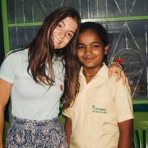 Volunteer from Portugal posing with children in Rishikesh, India with The Tarzan Way