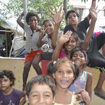 Children posing for pictures with volunteer with The Tarzan Way