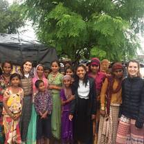 Volunteers from Italy and United Kingdom posing with women and children with The Tarzan Way