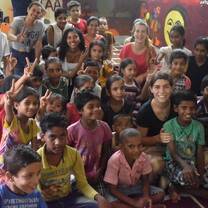 Street children and volunteers posing in Jaipur, India with The Tarzan Way