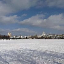 A river is covered by snow and complements the blue sky and white clouds.