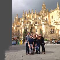 Students posing for a group photo in front of a beautiful building. 