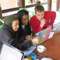 Students gathered around a computer talking. 