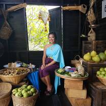 Girl sitting surrounded by fruits in baskets. 