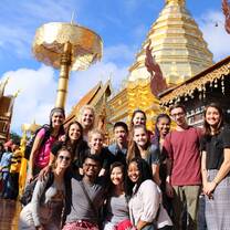Students posing for a group photo in front of a traditional temple. 