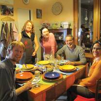 Group of students sitting around a table sharing dinner. 