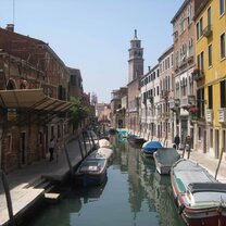 Study & Intern in Florence A canal with boats and beautiful buildings around it.