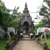 A Thai temple with stone elephant sculptures before the entrance. 