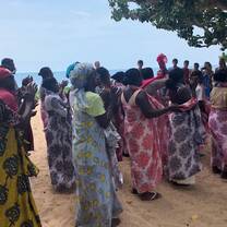 Women singing and dancing in brightly coloured traditional sarongs, during the opening ceremony of the clinic