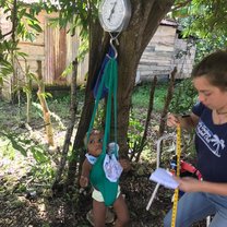 Weighing a baby during health clinics in the Bateyes