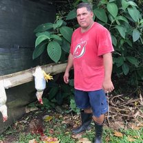Elias homestay dad posing after slaughtering two chickens...