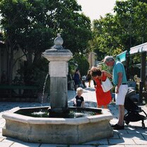 A family discovers a fountain at L'Isle-sur-la-Sorgue