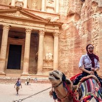 A girl (me) on riding a camel in Petra, in front of the famous Petra treasury 