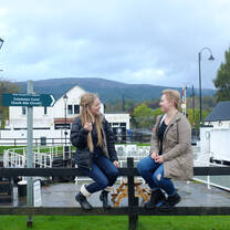 two girls sitting on a fence 