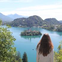 Photo of Lake Bled, Slovenia. In the centre of the lake sits an island with a church on it.