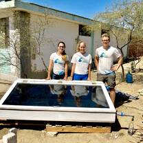 Volunteers with EcoSwell's solar distiller