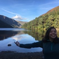 A girl smiling in front of a lake