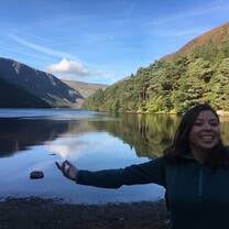 A girl smiling in front of a lake
