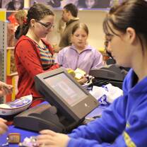 Retail staff assist kids buying snacks at the camp store