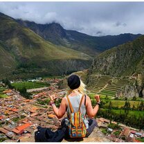 Me sitting off the edge of a cliff looking over the city of Ollantaytambo.
