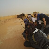 In the sands of the Sahara with Carpe Diem girls in desert taking selfie with camel