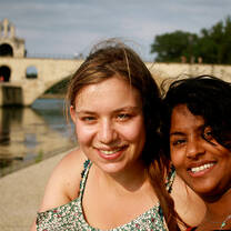 Students pose happily near the bridge