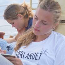 A+ World Academy students studying on deck
