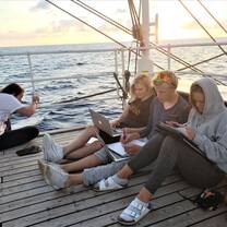 A+ World Academy students doing homework on deck