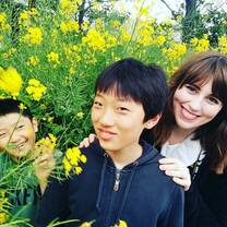 Intern with host brothers in field of yellow flowers