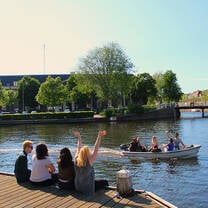 Students sit on the banks of the canal