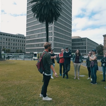 group on grassy hill near buildings