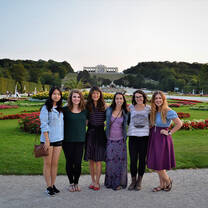 Students pose in front of a lovely flower garden