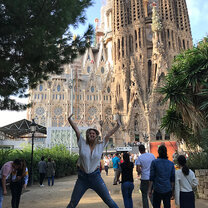 A student jumping for joy in front of a cathedral