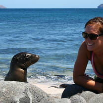 A student hanging out with a sealion on the beach
