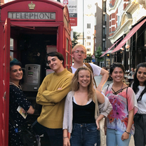 Students pose in one of London's famous telephone booths