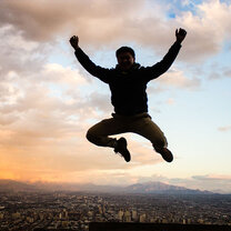 A student jumping on a mountain top overlooking Santiago, Chile.