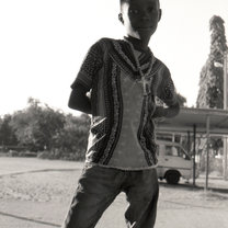 a local boy posing while a soccer game is being played