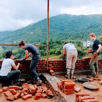 Work with local community members to construct a school.