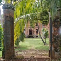 Looking through a broken gate into the primary courtyard and prison ruins on Ile Royale, largest of the Salvation's Islands, infamous French prison from 1852 to 1953.