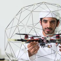 Arab male student from Khalifa University studies Quadprop drone that he built for robotics classes. Arab male student from Khalifa University studies Quadprop drone that he built for robotics classes.