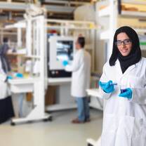 A lab tech at Khalifa University poses in front of the expensive equipment she is proud to work with 
