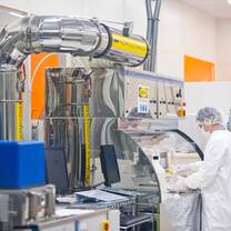 A student observes the reaction to his experiment in the clean room laboratory