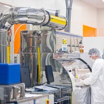 A student observes the reaction to his experiment in the clean room laboratory A student observes the reaction to his experiment in the clean room laboratory