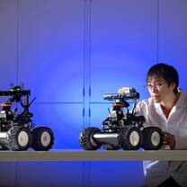 An east Asian student makes final adjustments to his robot before competitions begin