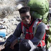 guy resting with pack on back in the desert