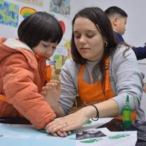 One of the alumni's from this program is pictured working with a student in China.