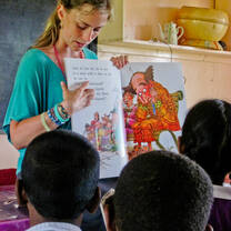 A female volunteer with children with in a teaching project in Fiji