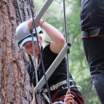 girl climbing ladder on high ropes course