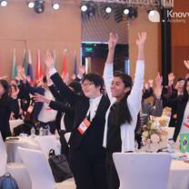Students wave at aModel G20 Youth Leadership Summit