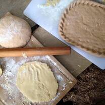 Making pizza in outdoor clay-cob oven